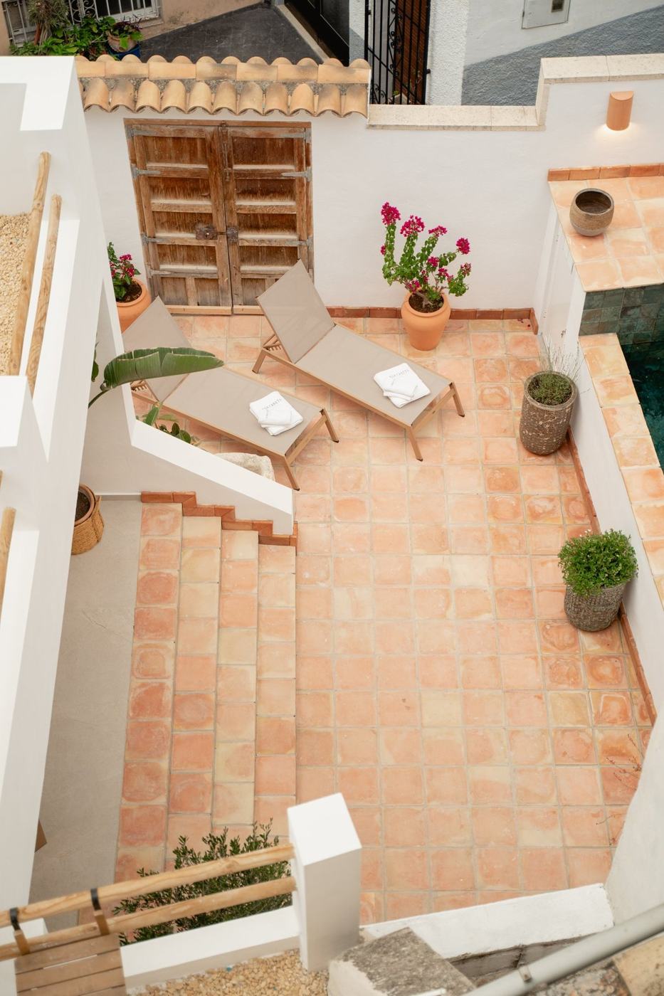 The courtyard from above: loungers, terracotta floor and bougainvillea.