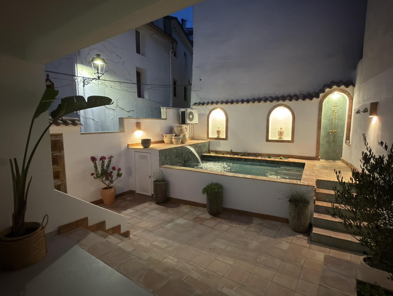 The courtyard at dusk: the lit pool and glowing niches.