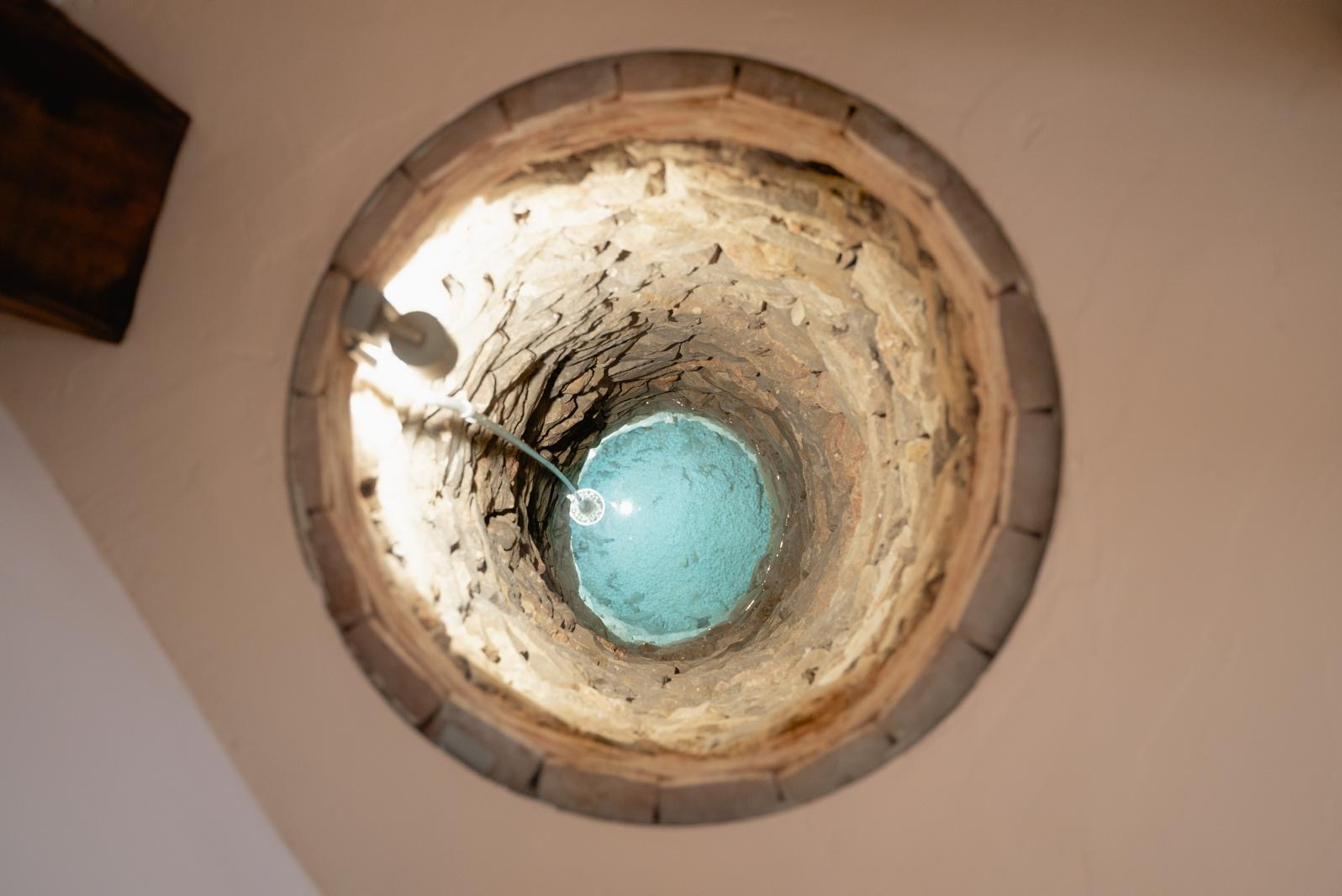 The entrance well seen from above through the glass: stone, water and light.