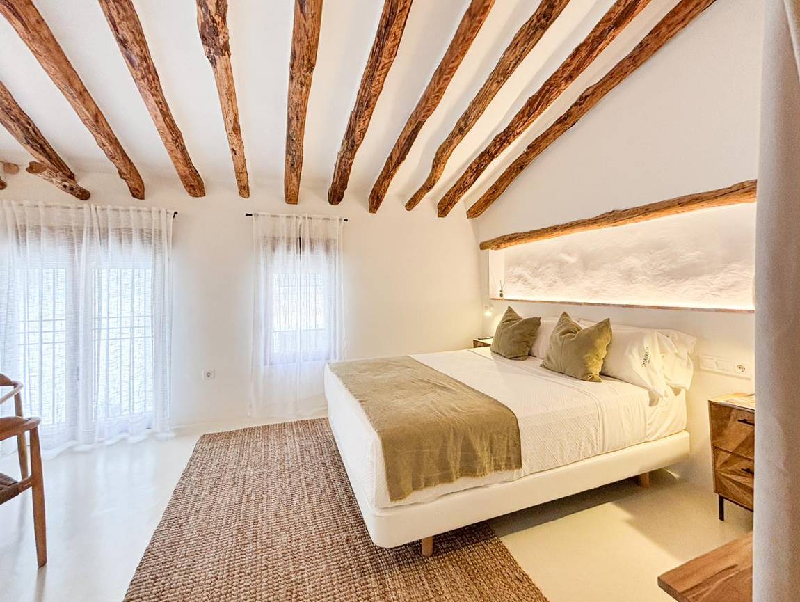 Manzanilla, main bedroom: niche above the bed and timber beams.